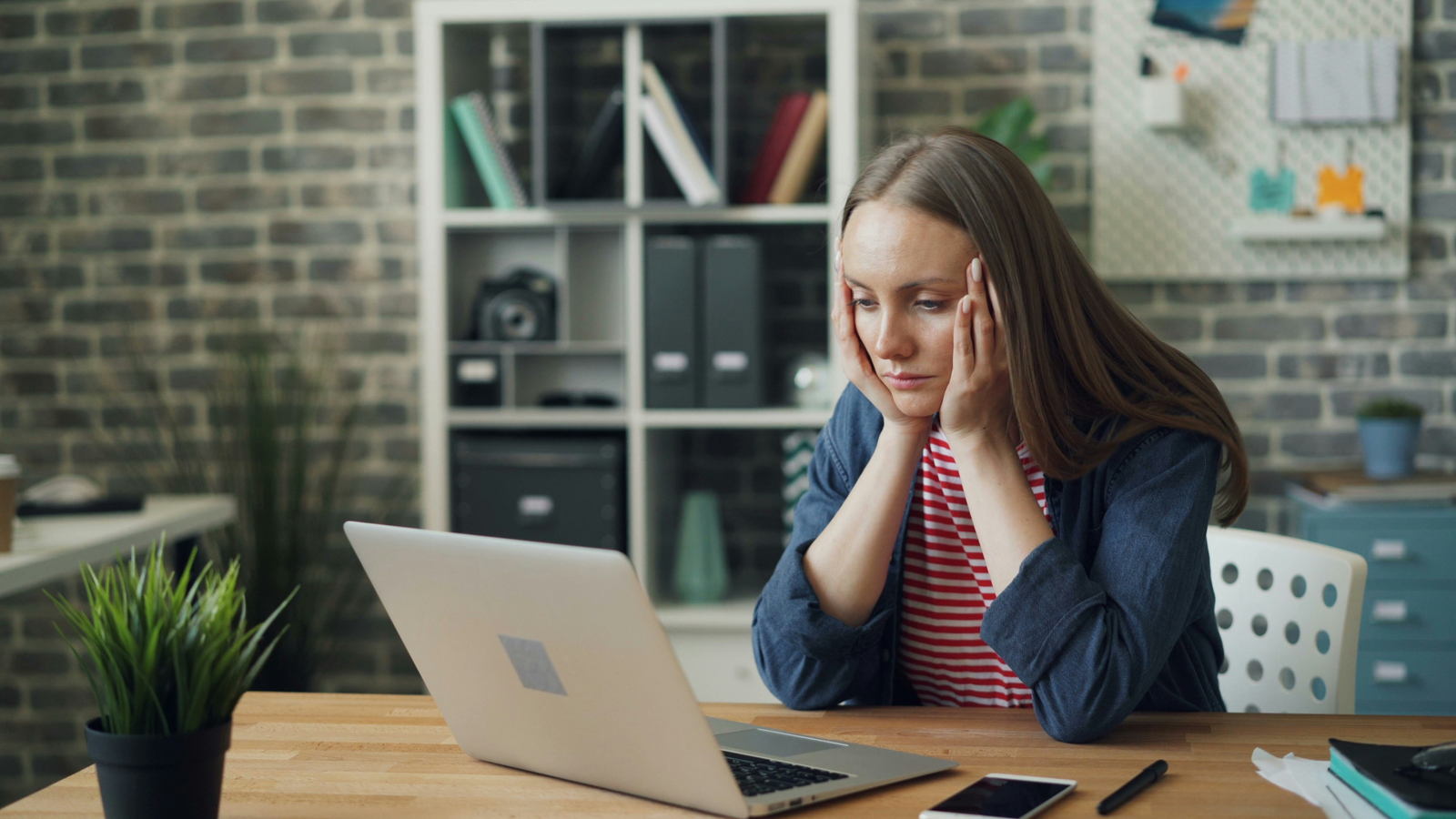 frustrated woman at her desk with laptop